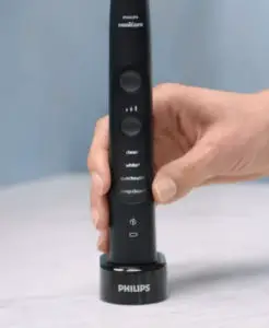 woman's hand putting Philips Sonicare ExpertClean 7500 on the charger