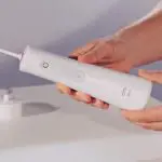 dentist holding Oral-B Aquacare 6 water flosser