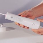 dentist holding Oral-B Aquacare 6 water flosser
