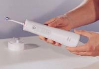 dentist holding Oral-B Aquacare 6 water flosser